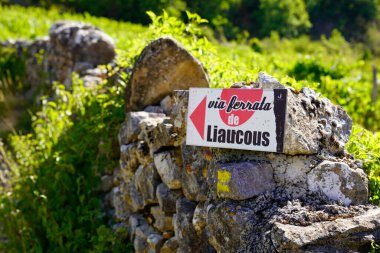 Signpost to via ferrata liaucous a mountaineering trail in france Mostuejouls near Millau clipart