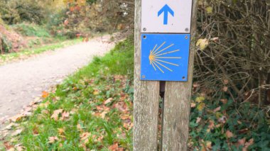 St. James Camino de Santiago logosunun Saint-Jacques-de-Compostelle yolu üzerinde ok olan sarı kabuk işareti