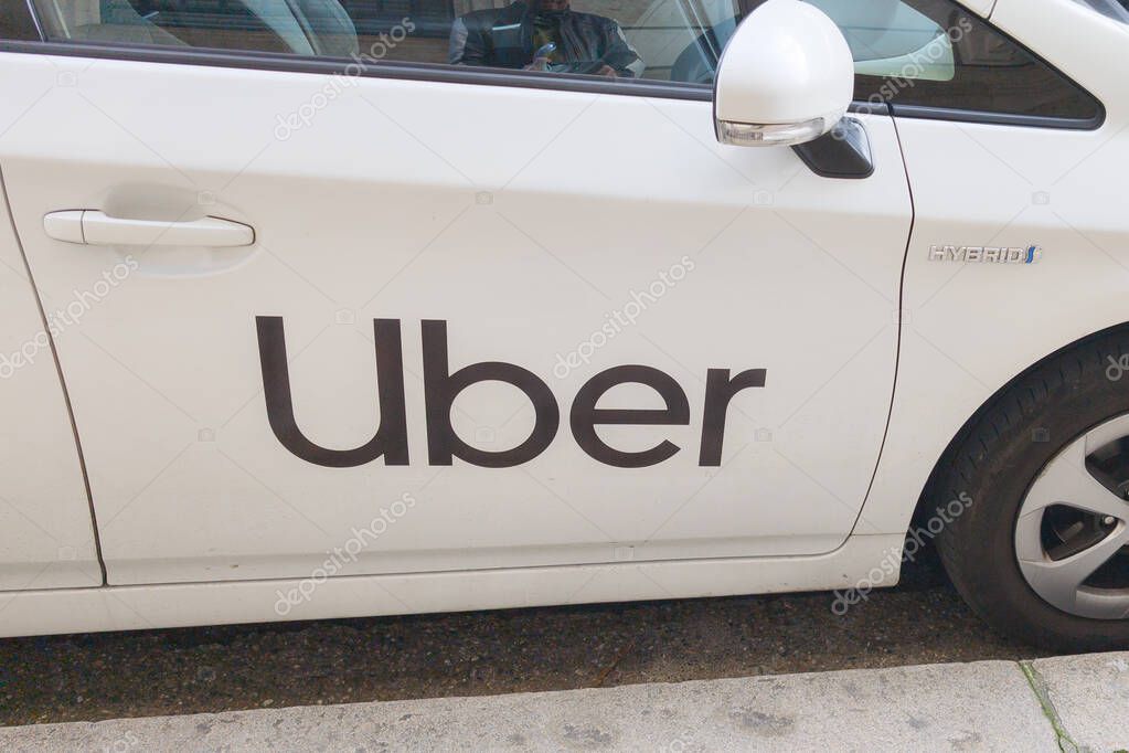 Bordeaux, France -  03 07 2025 : Uber car taxi online transportation american service brand text and logo sign on side of white vehicle