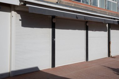 ön cephe kapalı dükkan kepenkleri dış beyaz kapı pencereleri bölgesel gri kapılı
