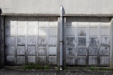 Eski yıpranmış ve paslı plastik kapı kapalı garaj binası cephesi