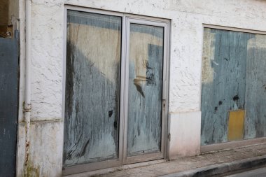 İflas ettikten sonra iç mekanı gizlemek için camları boyanmış bir dükkanın ön cephesi.