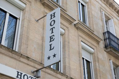 Şehir merkezinde iki yıldızlı ön duvar yüksek bina girişine eklenmiş otel imzası büyük harflerle.