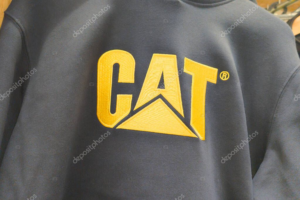 Bordeaux , France -  04 30 2025 : cat sign logo caterpillar and brand text on black yellow shirt in fashion shop signage us heavy equipment manufacturer store