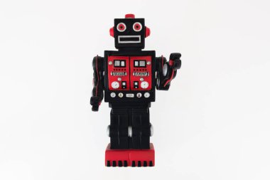 Beyaz arka planda eski kırmızı ve siyah antika robot oyuncağı nostaljik bir figür.