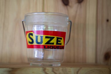 Bordeaux, Fransa - 05: 20 2025: likör logosu markasını suze etmek ve buz kovası üzerinde eski moda metinler imzalamak. Bar restoranının alkol barı duvarında acı aperatif jantian likörü reklamları yapmak.