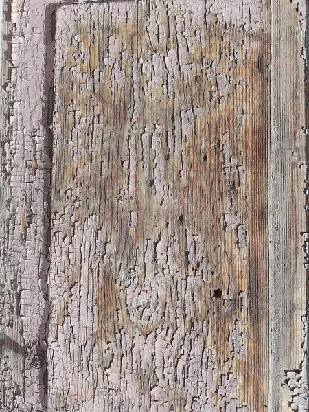 stock image This image captures the intricate textures of a weathered wooden surface with remnants of vintage blue paint peeling away over time. The rustic charm is evident in the layers of cracked and chipped paint that reveal the underlying wood grain, hinting