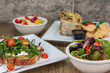 Önünde yeşil salata ve avokado tostu bulunan harika bir ziyafet..