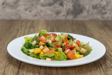 Tempting appetizer of garden salad full of winter vegetables served small plate.