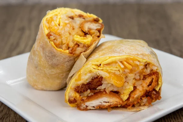 Egg and crispy potato breakfast burrito filled with rice, cheese, and salsa for a very large appetite.