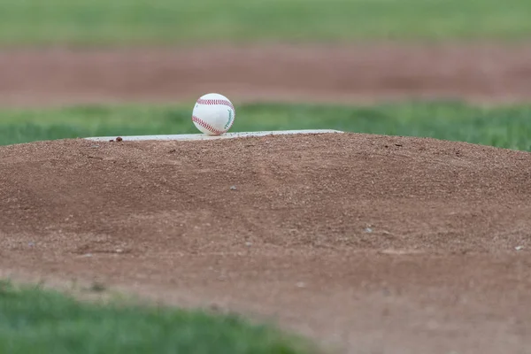 ピッチゴムは ゲームの日のための野球場のマウンドに新しいきれいなボールを持っています — ストック写真