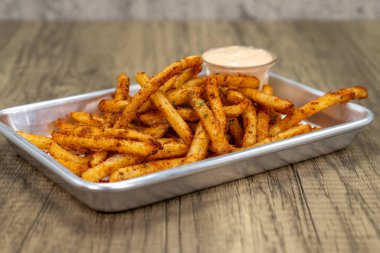 Acılı hardal soslu bir tepside kızarmış patates kızartması..