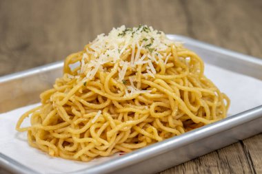 Gümüş tepside üst üste dizilmiş sarımsaklı erişte mezesi..