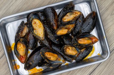 Tepside servis edilen tereyağlı midyelerin genel görünümü