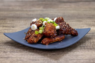 Teriyaki salamura edilmiş kanatlar Vietnam mutfağı olarak sunuluyor..