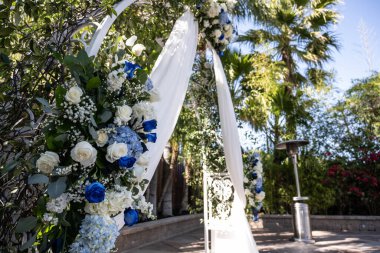Dantelli ve yeşilli renkli güller düğün yeri için sunağı süsleyin..