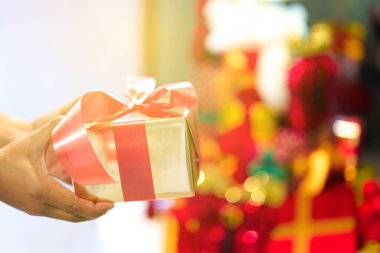 Elinde hediye paketi kurdelesi olan ya da doğum günü partisi için kırmızı kurdeleli bir adam. Mutlu yıllar ve Mutlu Noeller partisi özeti. Güzellik Xmas dekorasyonu ve Noel zamanı.