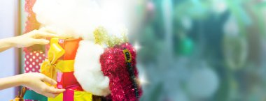 İnsanların elinde hediye paketi kurdelesi ya da doğum günü partisi bayramı afişi olarak kırmızı kurdele var. Mutlu yıllar ve Mutlu Noeller partisi özeti. Güzellik Xmas dekorasyonu ve Noel zamanı.