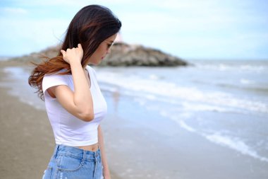 Yaz sahili geçmişi. Tatilde beyaz gömlekli genç Asyalı kadın portresi..