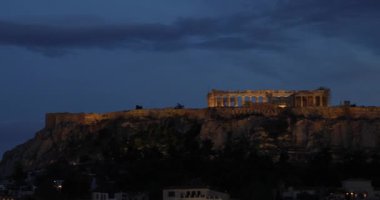 Akropolis akşam ışığında parlıyor, şehrin aydınlığında yıkanıyor.