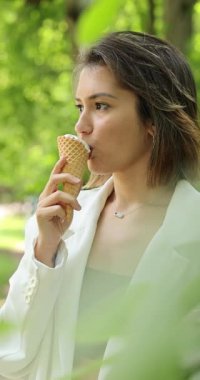 Yazın dondurma külahlı beyaz takım elbiseli çekici bir kadın.