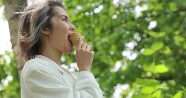 Yazın dondurma külahlı beyaz takım elbiseli çekici bir kadın.