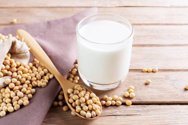 Tahta bir masada soya fasulyeli soya sütü. Organik kahvaltı, yüksek protein, sağlıklı tarım ürünleri, vejetaryen.