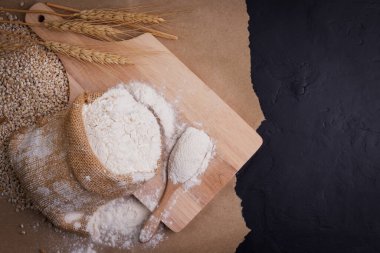 wheat flour in sacks With wheat ears on the table, black background.