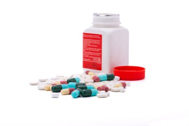 Kapsüllü renkli haplar ve ilaç şişeleri beyaz arka planda izole hastane eczanesi ilaç konsepti ve klinikleri dağıtıyor.