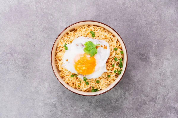 stock image Instant noodles or ramen with minced pork and boiled egg in white bowl on the table with copy space - top view