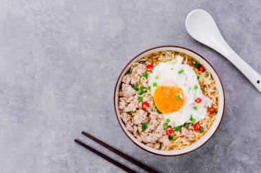 Makarna ya da domuz kıymalı ramen ve kaynamış yumurta fotokopi masasının üstünde.
