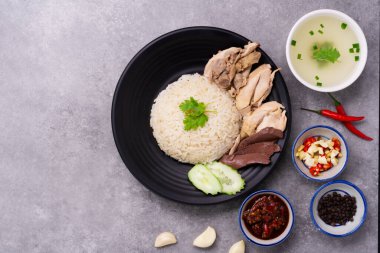 Siyah ahşap bir masa üzerinde tavuk pilavı tavuk çorbası, soslu tavuk pilavı Tayland yemeği ve Çin Singapur sosu.