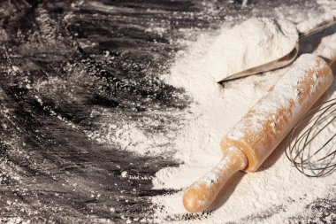 Buğday, arpa, pişirme, ekmek ve kurabiyelerden oluşan un ve kulaklar kırsal bir mutfaktaki ahşap masa zemininde düzenlendi. Üst görünüm.