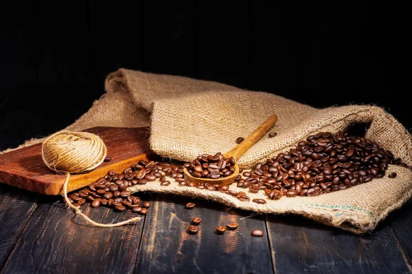 新鲜咖啡豆放在黑色木制桌子上 烤咖啡豆咖啡咖啡咖啡卡布奇诺 巴里斯塔 深色背景 免版税图库图片
