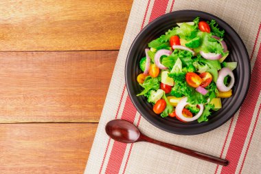 Taze domatesli, soğanlı, ıspanaklı ve marullu sağlıklı organik salata. Kilo vermek için diyet menüsü. en üstteki görünüm