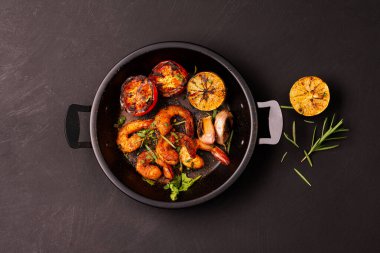 Limonlu ızgara karides. Siyah arka planda sarımsak. Deniz ürünleri. Üst görünüm.