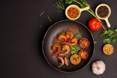 Limonlu ızgara karides. Siyah arka planda sarımsak. Deniz ürünleri. Üst görünüm.