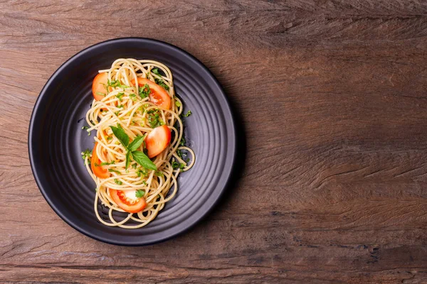 将意大利面或炒面 番茄酱和大虾放在一个黑色盘子里 放在木制桌子的背景上 顶部视图 — 图库照片