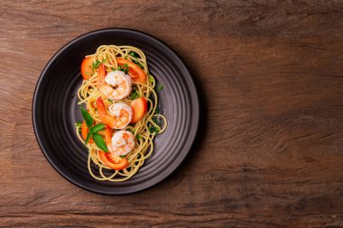 Karıştırılmış spagetti ya da ahşap bir masa arkasında karides ve domates sosu. Üst görünüm.