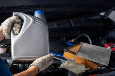 Araba yağlayıcı galon ya da motor arka planındaki gri şişeden yağ değiştirme servisi, oto tamirhanesi teknolojisi ve ulaşım endüstrisi