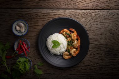 Tahta masaya yerleştirilmiş baharatlı Tayland yemeği ve fesleğenli karides. Üst görünüm.