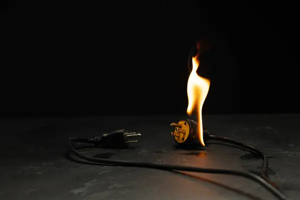 An electrical plug fire is caused by a short circuit of electrical current. Concept of prevention of danger. Using non-standard equipment, damaged equipment