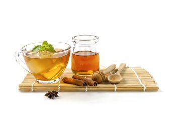 Beyaz arka planda buzlu, ballı ve nane yapraklı güçlü bir tadı olan bir fincan çay..