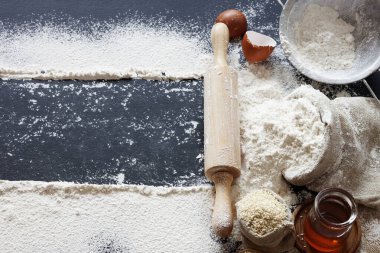 Çeşitli aksesuarlı buğday un torbaları ve masaya yayılan beyaz toz ile bir mesaj yazmak için yer var - üst görünüm.