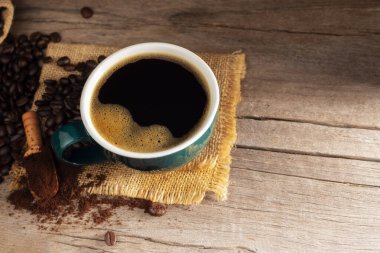 Yeşil fincanlı sade kahve ve kavrulmuş kahve fasulyesi esmer şeker ve koyu arkaplanda düz bir fincan sıcak espresso.