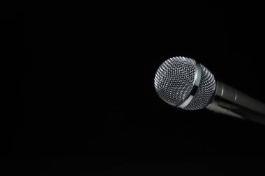 Stüdyoda siyah ve siyah arka planda siyah ve gümüş mikrofonlar var. Profesyonel kayıt ekipmanları. Üst görünüm.