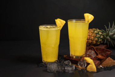 Bahçeden taze ananas ile ananas suyu sağlıklı yaz yemekleri, kokteyller, doğal içecekler yeşil yapraklar. Siyah arkaplanda izole.