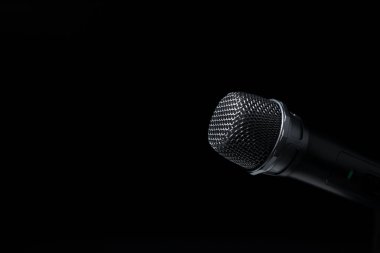 Stüdyoda siyah ve siyah arka planda siyah ve gümüş mikrofonlar var. Profesyonel kayıt ekipmanları. Üst görünüm.