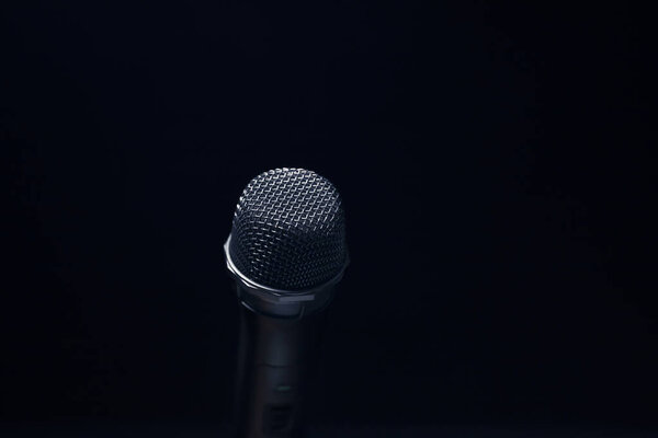 Black and silver microphones in the studio on a black and dark background. Professional recording equipment. Top view.