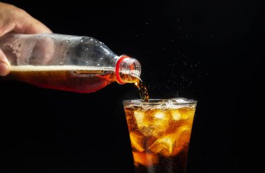 Bardakta buzla köpüklü suyu yakından çek. Siyah arkaplana yerleştirilmiş